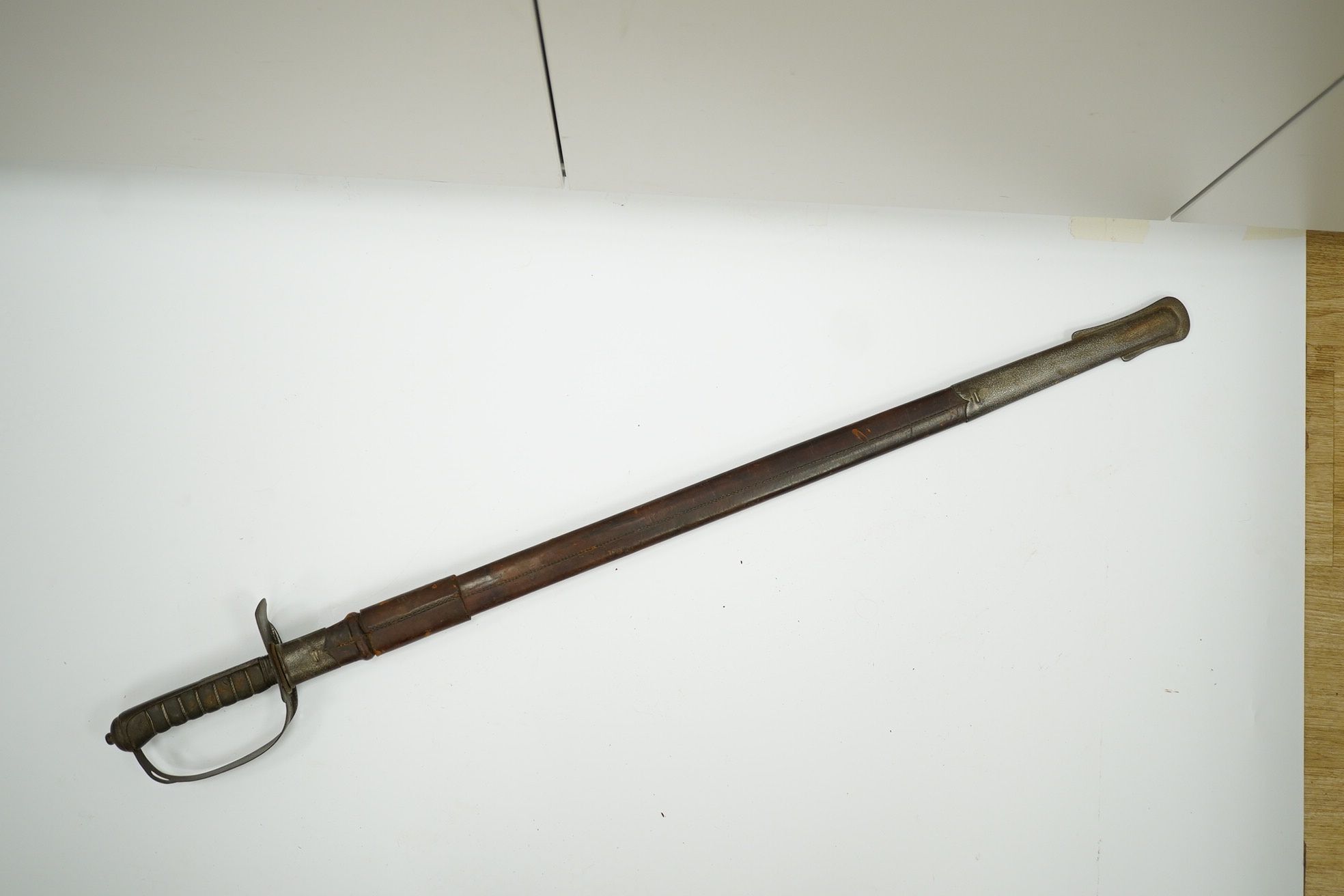 A mid-19th century British infantry sword, by Mole, Birmingham, marked I.S.D., in its leather scabbard with iron chape. Condition - poor, surface rust and knuckle guard significantly cut down.